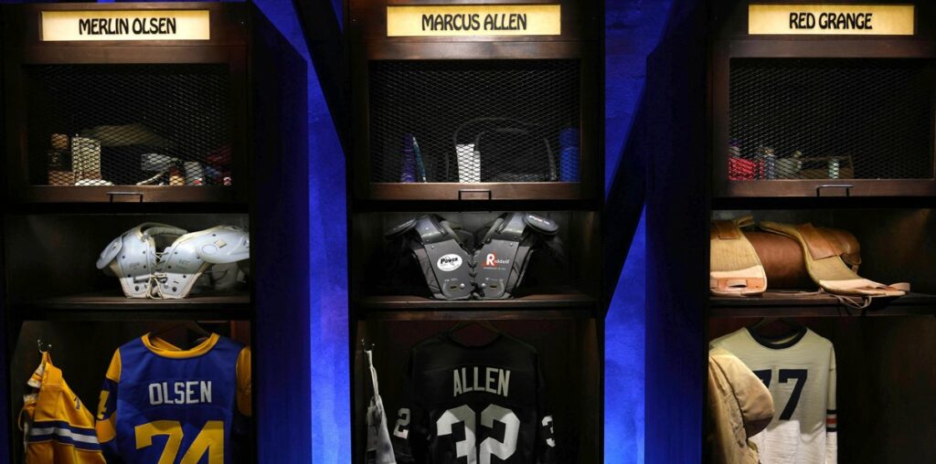 Aug 4, 2023; Canton, OH, USA; A locker room exhibit featuring Merlin Olsen, Marcus Allen and Bears Legend Red Grange at the Pro Football Hall of Fame. Mandatory Credit: Kirby Lee-USA TODAY Sports